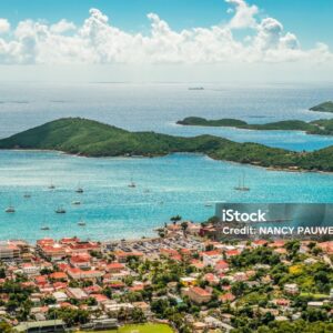 Colorful aerial view landscape of town and harbor of Charlotte Amalie in St Thomas, US Virgin Islands, Caribbean. Blue sky and white clouds, green mountains in the background. Panoramic cruise and travel image.